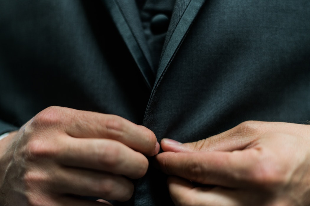 A person buttoning their blazer jacket